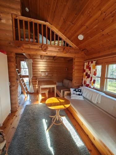 a room with a couch and a table in a cabin at Kotikolo in Inari