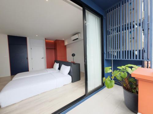 a bedroom with a bed and a large window at TERREST MAISON On Nut in Bangkok