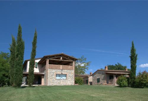 a large brick house with trees in a yard at Agriturismo I Gergoni in Monteleone dʼOrvieto