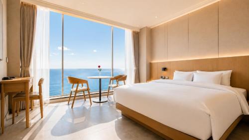 a bedroom with a bed and a desk and a large window at Hotel Laon in Busan