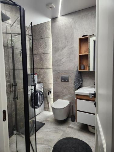 a bathroom with a shower and a toilet and a sink at Batumi View apartment in Kachretʼi