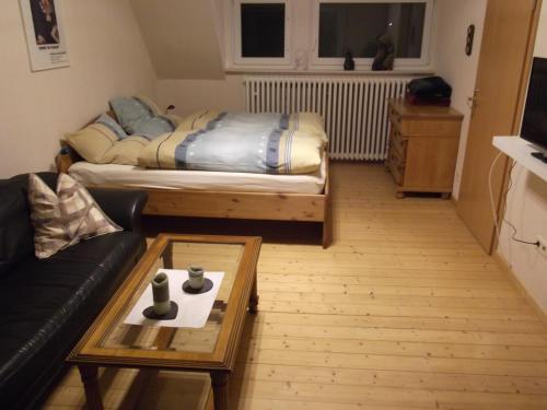 ein Wohnzimmer mit einem Bett und einem Couchtisch in der Unterkunft Gute Nacht Ferienwohnung in Halle Westfalen