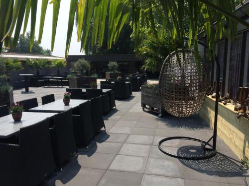 a patio with tables and chairs and palm trees at Hotel Restaurant Cafe Houben in Nunhem