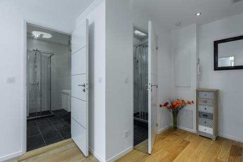 une salle de bain avec des armoires blanches et un vase de fleurs dans l'établissement Nice Beach - Promenade Des Anglais, à Nice