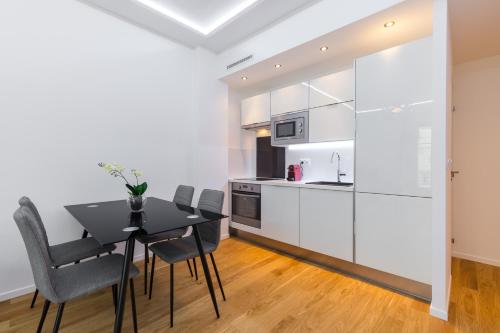 une cuisine et une salle à manger avec une table et des chaises noires dans l'établissement Nice Beach - Promenade Des Anglais, à Nice