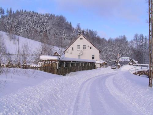 a house on a road covered in snow at Biotanika in Michałkowa