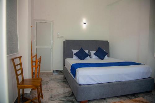 a bedroom with a large bed with blue pillows at Celanika resort in Kandy