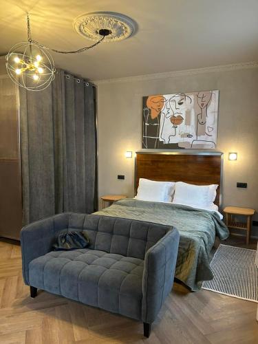 a bedroom with a bed and a blue couch at Aparthotel in Chişinău