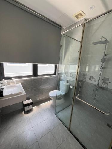 a bathroom with a shower and a toilet and a sink at Arcadia homestay in Phú Quốc