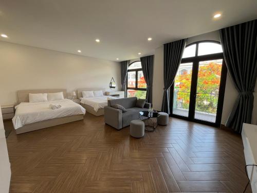 a bedroom with two beds and a couch and a chair at Arcadia homestay in Phú Quốc