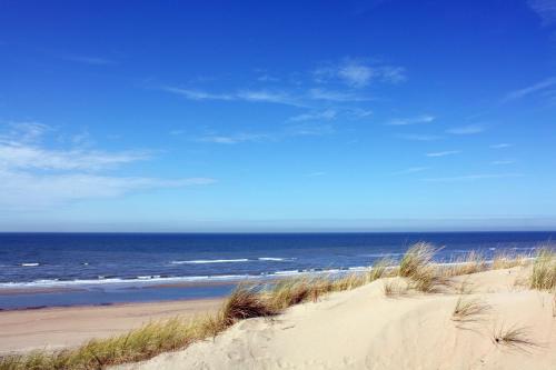 a sandy beach with the ocean in the background at Van der Valk Hotel Akersloot / A9 ALKMAAR in Akersloot