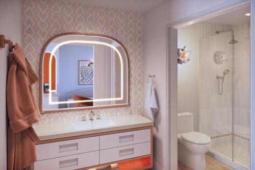 a bathroom with a sink and a toilet and a mirror at Royal Palm South Beach Miami, a Tribute Portfolio Resort in Miami Beach