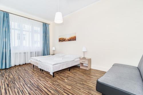 a bedroom with two beds and a couch at Baltic Plaza Gdynia - MAXIMAL in Gdynia