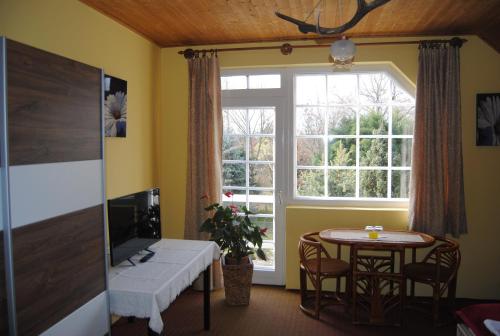 a living room with a table and a window at Villa Hedi in Dunakiliti