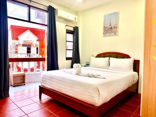 a bedroom with a bed with a stuffed animal on it at Vista Inn Patong in Patong Beach