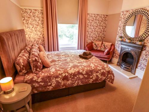 a bedroom with a bed and a chair and a fireplace at 105 Spilsby Road in Boston