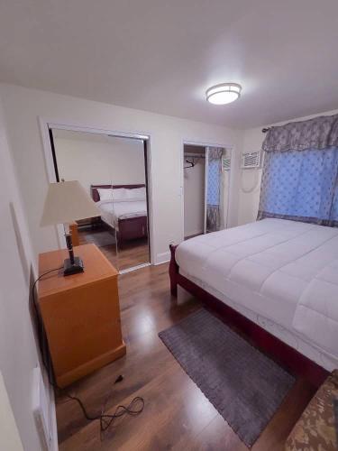 a bedroom with a bed and a lamp and a mirror at Residence Tacoma in Tacoma
