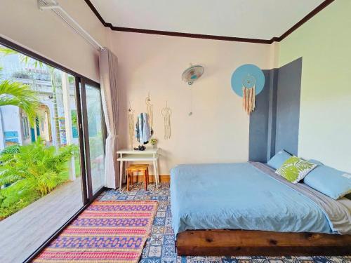 a bedroom with a bed and a large window at Gió Homestay and Coffee in Ấp Khánh Phước (1)