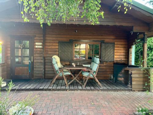 a wooden cabin with a table and two chairs at Haus Tausendschön in Torgelow