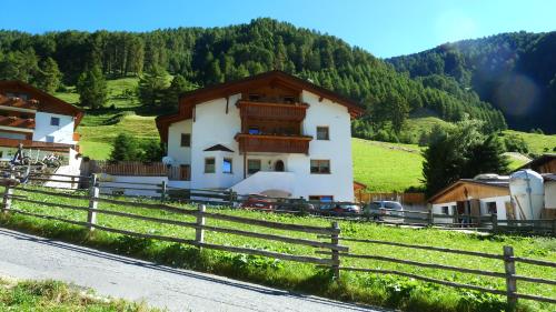 ein Haus auf einem Hügel mit einem Zaun in der Unterkunft Wastlhof in Mals im Vinschgau