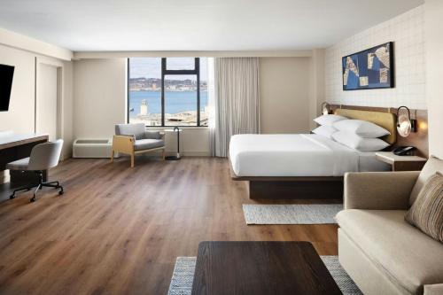 a hotel room with a bed and a living room at Delta Hotels by Marriott Halifax Downtown in Halifax