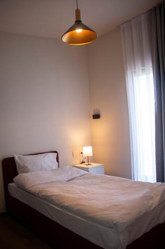 a bedroom with a bed with a lamp and a window at Loft Orman Tatil Köyü in Ankara