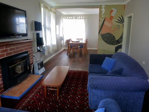 a living room with a blue couch and a fireplace at Salt 112 House in Albany