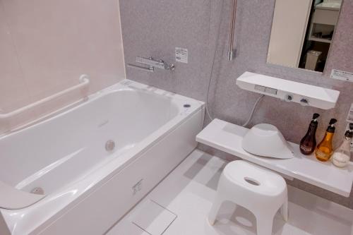 a white bathroom with a tub and a toilet at Nature Resort in Kawamoto in Kawamoto