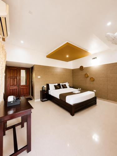 a large bedroom with a large bed and a desk at Chilanka Lake View Resort in Alleppey