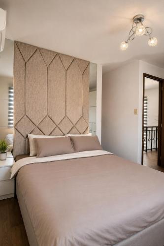 a bedroom with a large bed with a headboard at Nicholas Residence in Silang