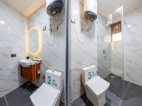 a bathroom with two toilets and a sink at Hotel Aeroporto in New Delhi