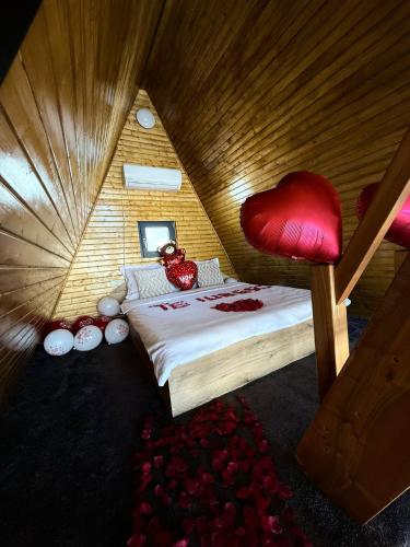 a bedroom with a bed with a red heart chair at DnD Mountain Escape in Holbav