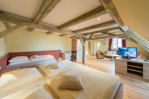 a bedroom with two beds and a television in it at Hotel Theophano in Quedlinburg