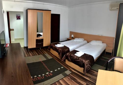 una camera d'albergo con due letti e uno specchio di ApartHotel Zorilor a Cluj-Napoca