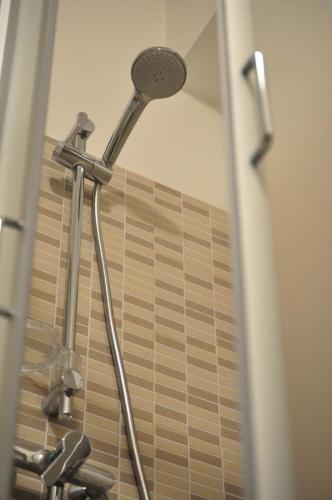 a shower with a shower head in a bathroom at Artisti Rooms in Ravenna