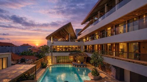 an exterior view of a building with a swimming pool at BLive Coliving Canggu in Canggu
