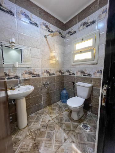 a bathroom with a toilet and a sink at عماره in Sheikh Zayed