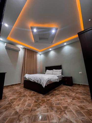 a bedroom with a bed and a ceiling with lights at عماره in Sheikh Zayed
