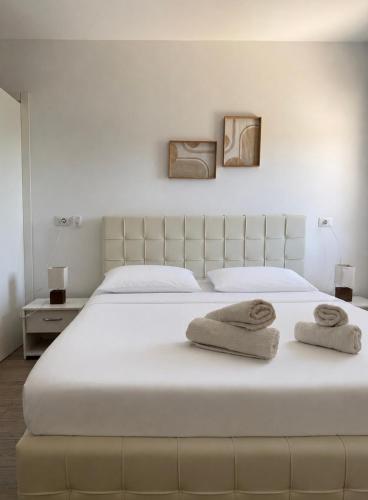 ein Schlafzimmer mit einem großen weißen Bett, auf dem Handtücher liegen in der Unterkunft Summer Home in Gjilek