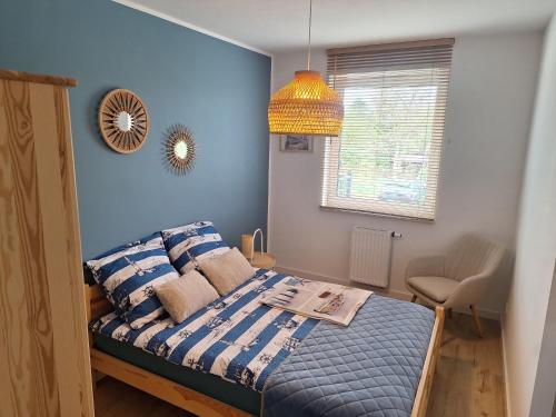 a bedroom with a bed with blue walls at SEA Apartment in Malbork