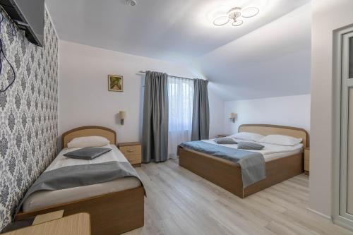 a bedroom with two beds and a window at Pensiunea Gaby in Cluj-Napoca