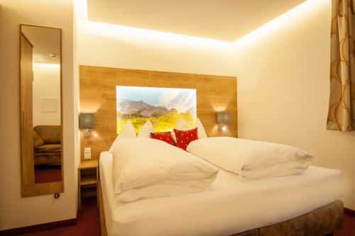 a bedroom with two beds and a painting on the wall at Landhaus & Appartementhaus Haussteiner in Dorfgastein