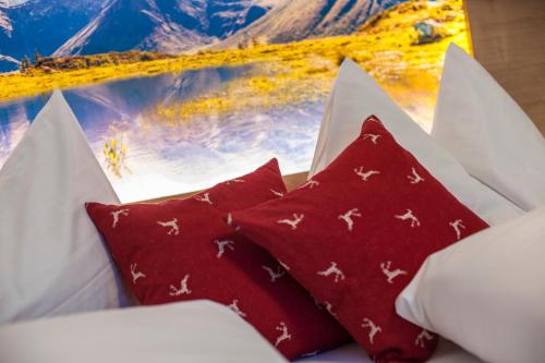a group of red pillows sitting on a couch at Landhaus & Appartementhaus Haussteiner in Dorfgastein