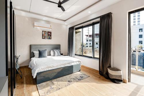 a bedroom with a bed and a large window at HomeGround Sector 89 -1RK in Gurgaon