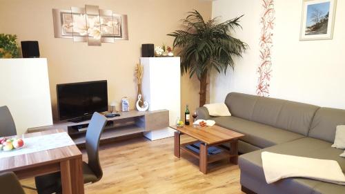 ein Wohnzimmer mit einem Sofa und einem Tisch in der Unterkunft Ferienwohnungen Villa Waldblick in Zempin