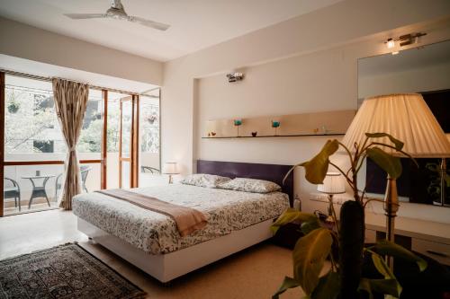 a bedroom with a bed and a balcony at LUHO Grande in Bangalore