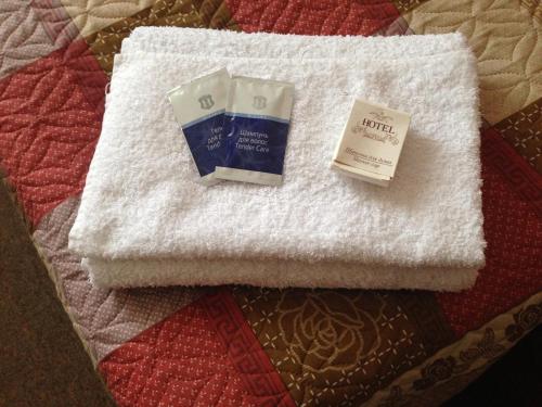 Danilov的住宿－Hotel Sot，白色毛巾,包括一瓶肥皂和一本书