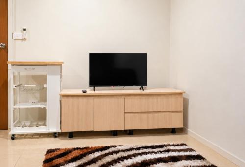 a flat screen tv sitting on top of a wooden cabinet at The Zef Apartment in Nadi