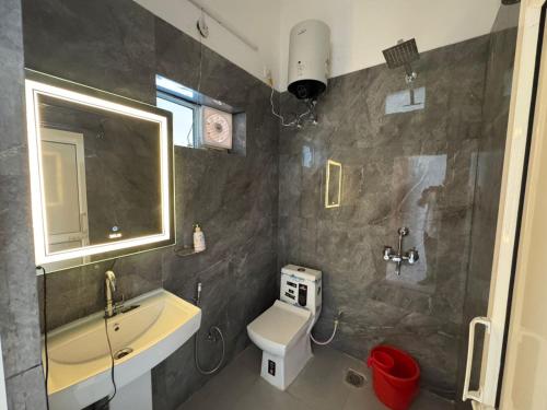 a bathroom with a sink and a toilet and a mirror at Mangalm Farm & Resort in Greater Noida