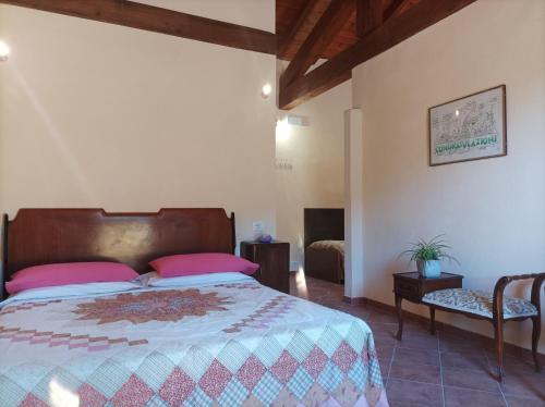 a bedroom with a large bed with pink pillows at Bed and Breakfast da Pio in Castelveccana